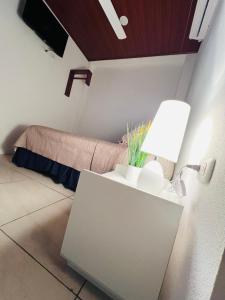 a room with a table with a lamp and a bed at Hotel Posada Casa Real in León