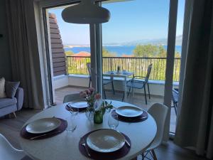 a white table with plates and glasses on a balcony at Vila Primorka-Apartmani Lavanda in Šilo