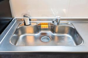 a stainless steel sink with a soap dispenser in it at AMP FLAT Marron Hontosu in Tosu +35 photos
