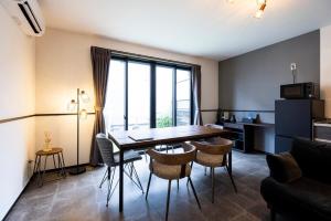 a living room with a dining room table and chairs at AMP FLAT Marron Hontosu in Tosu
