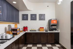 a kitchen with wooden cabinets and a counter top at Hampton Inn Carrollton KY in Carrollton