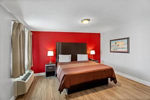 a red bedroom with a bed and a red wall at Rodeway Inn Kingsland - Lake LBJ in Kingsland +23 photos