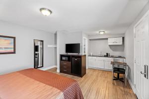 a hotel room with a bed and a kitchen at Rodeway Inn Kingsland - Lake LBJ in Kingsland