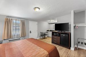 a hotel room with a bed and a flat screen tv at Rodeway Inn Kingsland - Lake LBJ in Kingsland