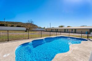 a blue swimming pool in front of a building at Rodeway Inn Kingsland - Lake LBJ in Kingsland