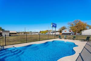 a swimming pool with a fence and a rv at Rodeway Inn Kingsland - Lake LBJ in Kingsland