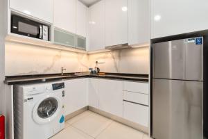 una cucina bianca con lavatrice e lavastoviglie di Societe Suites By iHost Global a Kuala Lumpur