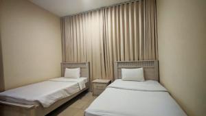 twee bedden in een kleine kamer met rokken bij Al Khaleej Plaza Furnished Hotel Apartments in Ajman 