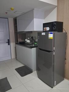 a small kitchen with a refrigerator in a room at Athenas Cozy Place in Mandaue City