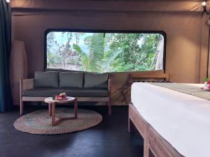 una camera da letto con un letto, un divano e un tavolo di Serenity Sands - Island Glamping a Bounty Island