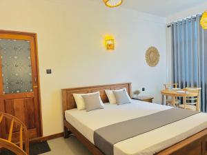 a bedroom with a large bed and a table at Crystal Pearl Villa, Weligama - 3min to beach in Weligama