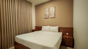 a small bedroom with a bed with white sheets at Al Khaleej Plaza Furnished Hotel Apartments in Ajman 