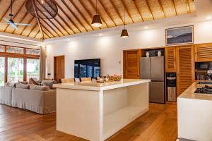 an open kitchen and living room with a couch at Villa Madu Mentawai in Katiet