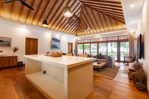 a kitchen with a large island in a living room at Villa Madu Mentawai in Katiet