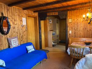 a living room with a blue couch and a table at Chalet Lueg uf Belalp in Rosswald