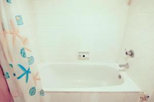 a bathroom with a shower with a white tub at Wish Inn Chidlom - Ratchadamri 2 in Pratunam +36 photos
