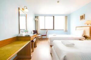 a hotel room with two beds and a desk at Wish Inn Chidlom - Ratchadamri 2 in Pratunam