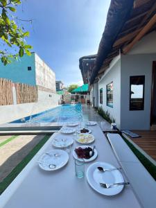 een tafel met borden met eten erop naast een zwembad bij 50pax private Beachfront Villa with pool in Nasugbu +30 foto's