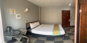 ein kleines Zimmer mit einem Bett und einem Tisch und einem Bett sidx sidx in der Unterkunft Nasa Hotel in Phuket + 44 Fotos