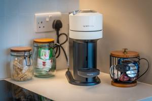 a kitchen counter with a coffee maker and jars on it at Charming coastal escape in Eastbourne