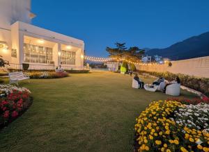 a group of people sitting on chairs in a park at Hotel Asia Vaishnodevi Katra in Katra