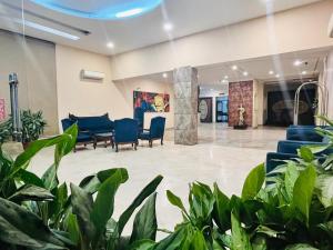 a lobby with blue chairs and plants at Hotel Asia Vaishnodevi Katra in Katra