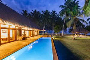 a villa with a swimming pool and a resort at Villa Madu Mentawai in Katiet