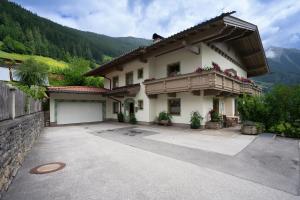 a large white house with a patio and mountains at Panoramablick Ferienwohnung Schiestl in Brandberg