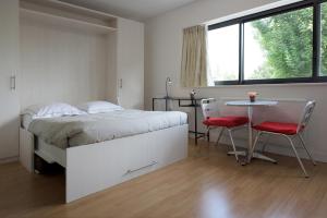 マルク・アン・バルールにあるAppartement Lille Metropolysのベッドルーム1室(ベッド1台、テーブル、椅子付)