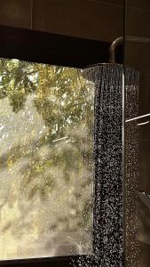 een douche met water uit een raam bij Wateera Jebel Sifah-Beachfront in As Sīfah