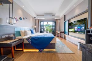 a bedroom with a bed and a flat screen tv at Phoenix Ancient Hill Riverside View Hotel- Offers free one-way high-speed rail pick-up service - Afternoon tea - Self-service laundry - Baggage storage - Travel planning in Fenghuang County