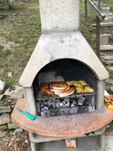 a stone oven with food cooking on a grill at Chalet BERGliebe Willingen- Nähe Skywalk in Willingen