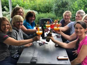 a group of people sitting around a table with glasses of beer at Chalet BERGliebe Willingen- Nähe Skywalk in Willingen