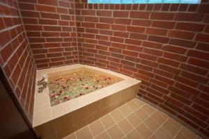 a brick shower with a tub filled with balls at 猫とピアノと星空のリゾートブティックコテージ -Starry Forest Cottage Okinawa- in Onna +61 photos