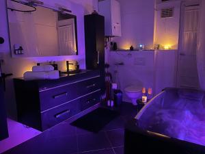 a kitchen with a bath tub in a room with purple lighting at Beautiful condominium with jacuzzi in Brussels