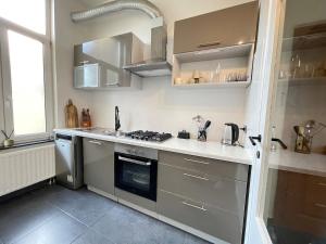 a kitchen with stainless steel appliances and a window at Beautiful condominium with jacuzzi in Brussels
