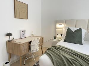 a bedroom with a desk and a bed and a desk and chair at Beautiful condominium with jacuzzi in Brussels