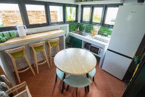 a kitchen with a table and chairs and a refrigerator at Baan Rot Fai Krabi Platform 2 in Ao Nam Mao