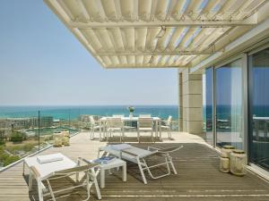 a patio with a table and chairs on a deck at The Ritz-Carlton, Herzliya in Herzliya