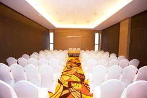 an empty room with white chairs and a stage at Citadines Connect Airport Jakarta Hotel in Tangerang