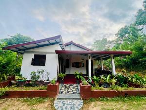 a small white house with a red roof at Sea Paradise Hidden Villa in Tangalle