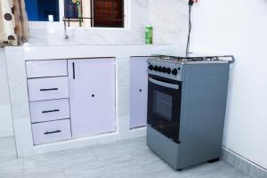 a kitchen with a stove and a white counter at Raels home in Mombasa +3 photos