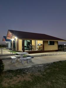 a picnic table and benches in front of a building at บ้านไร่สกายดาวเขาใหญ่ in Ban Nong Khung