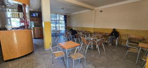 ein Restaurant mit Tischen und Stühlen und einer Person, die in einem Raum sitzt in der Unterkunft Temesegen Hotel in Aksum