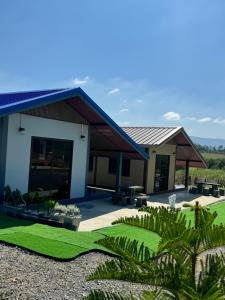 a house with a green lawn in front of it at บ้านไร่สกายดาวเขาใหญ่ in Ban Nong Khung