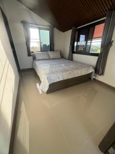 a small bedroom with a bed and two windows at บ้านไร่สกายดาวเขาใหญ่ in Ban Nong Khung +11 photos