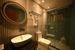 a bathroom with a sink and a toilet and a mirror at Munnar Peak Paradise in Devikolam