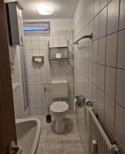 a bathroom with a toilet and a sink and a tub at MeerZeit in Emden