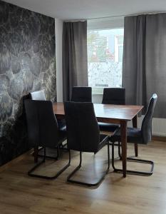 a dining room with a wooden table and chairs at MeerZeit in Emden