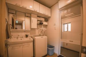 een kleine badkamer met een wastafel en een koelkast bij 波音ハウス in Yugawara +71 foto's